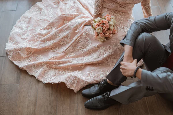 亚洲新娘身穿橙色礼服 手持花束 与新郎一起坐在地板上 — 图库照片