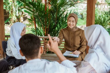 Kamu hizmetleri öğretmeni öğrencileri açık hava dersi sırasında soru sormaya davet eder.