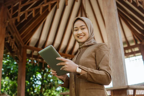 Asiatische Lehrerin Hijab Lächelt Die Kamera Während Sie Ein Tablet — Stockfoto