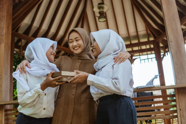 Sukacita Seorang Guru Perempuan Terselubung Sebagai Dua Siswa Perempuan Memberikan — Stok Foto