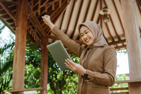 Podekscytowana Młoda Nauczycielka Hidżabie Patrząca Tablet Altanką Tle — Zdjęcie stockowe