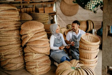 Geleneksel bambu ürünlerine gülümseyen iki işçi