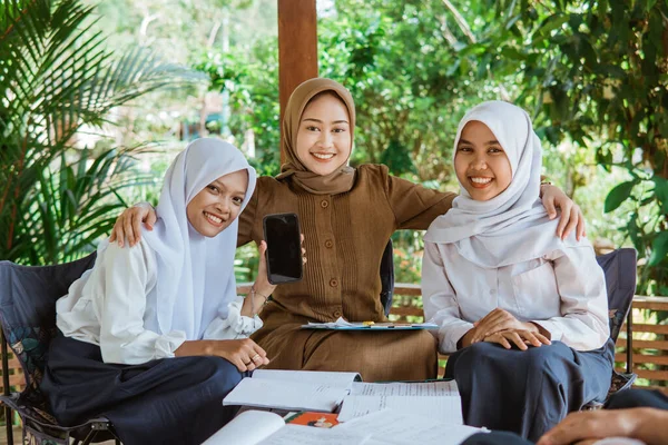 Leraar Veil Omarmt Twee Vrouwelijke Studenten Terwijl Hun Mobiele Telefoon — Stockfoto