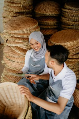 Geleneksel bambu ürünlerine gülümseyen iki işçi