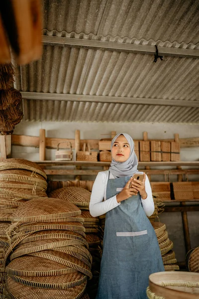 Asyalı kadın sanat eseri satıcısı atölyesindeyken bir şeyi merak ediyor.