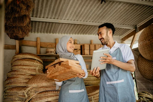 アジア系イスラム教徒の女性とそのパートナーが竹製品をチェックしています — ストック写真