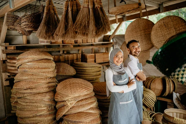 イスラム教徒の夫婦は竹の店の前でカメラに向かって笑顔で立っていました — ストック写真