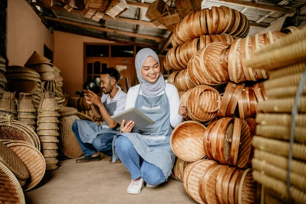 オンラインショップで伝統的な竹製品をチェックするためにタブレットを使用して魅力的なイスラム教徒の女性 — ストック写真