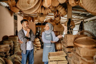 Örgü bambu satıcısı ürünlerini dükkânda müşteriye sunuyor.