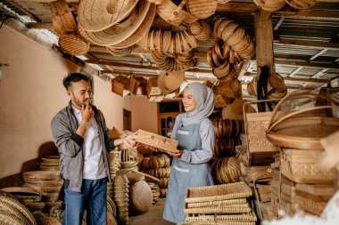 Örgü bambu satıcısı ürünlerini dükkânda müşteriye sunuyor.