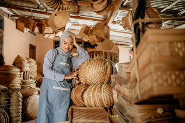 Depoda başını tutarken stres yapan genç bir işçi.