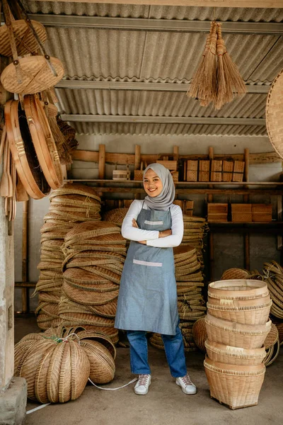 Mutlu gülümseyen genç kadın satıcı tesettürlü kollarını kavuşturup kameraya bakıyordu.