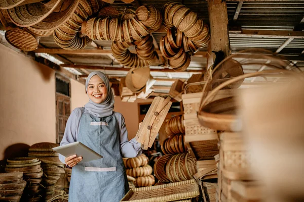 Atraktivní Muslim Žena Pomocí Tabletu Zkontrolovat Své Tradiční Bambusové Produkty — Stock fotografie