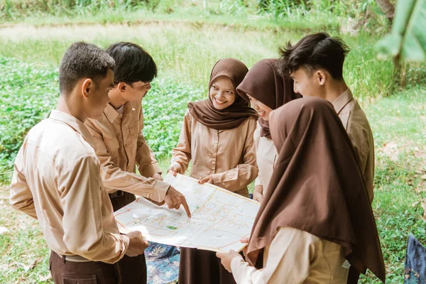 Pojke Scout Med Finger Pekar Kartan Medan Chatta Med Grupp — Stockfoto