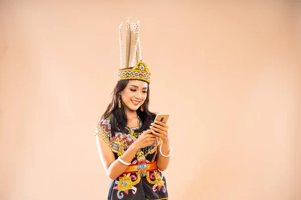 昼間の部族の伝統的な服を着たアジアの女性は 孤立した背景で電話を使いながら笑っています — ストック写真