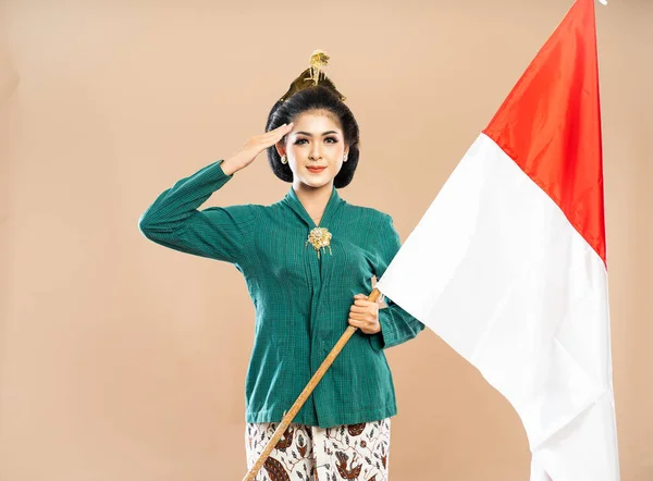 Azjatycka Kobieta Zielonej Kebaya Stojąc Pozdrowieniami Trzymając Indonezyjską Flagę Odosobnionym — Zdjęcie stockowe
