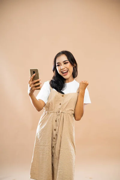 Feliz Asiático Mujer Casual Ropa Apretando Mano Mientras Mira Teléfono —  Fotos de Stock