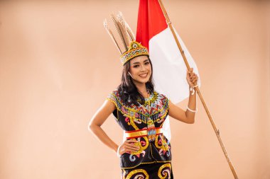 Orta boy, King Bibinge 'deki Asyalı kadın elini beline koydu ve izole edilmiş arka planda Endonezya bayrağı kaldırdı.