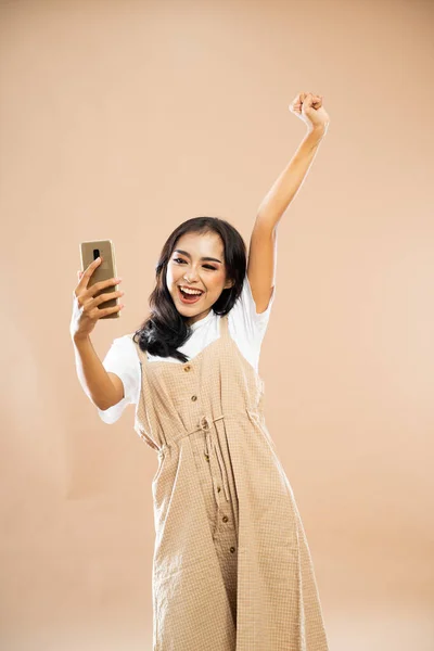 Mulher Asiática Roupas Casuais Levantando Mão Enquanto Olha Para Telefone — Fotografia de Stock
