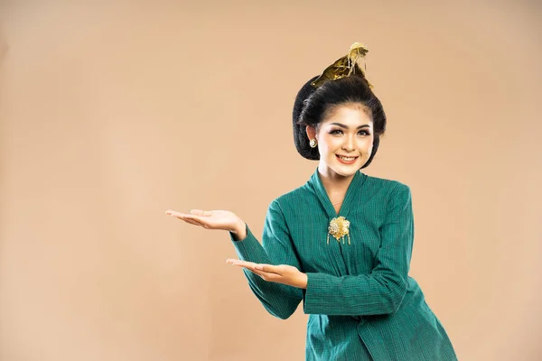 穿着绿木瓜衣服的亚洲女人站在一旁 用双手在与世隔绝的背景下指指点点着自己 — 图库照片