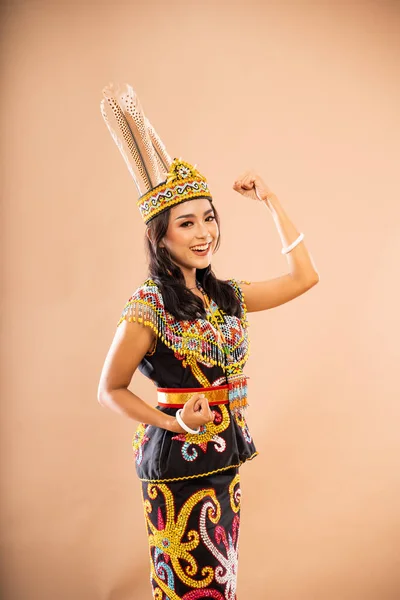 白昼の部族の伝統的な服に身を包んだアジア人女性は笑顔で立ち上がり孤立した背景で腕を食いしばった — ストック写真
