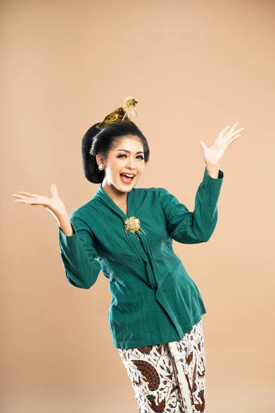 緑色のケバヤのアジア系女性は笑顔で立ち両手を隔離された背景で開き — ストック写真