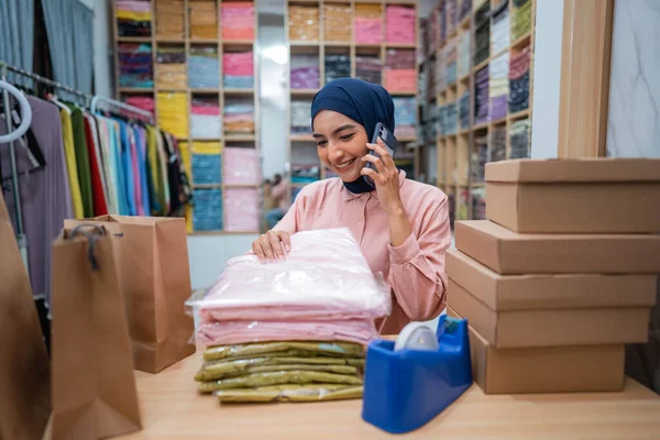 在发货前检查产品时打电话给迷人的穆斯林妇女业主 — 图库照片