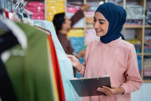 穆斯林妇女在商店里头戴头巾检查自己的时尚服饰 — 图库照片