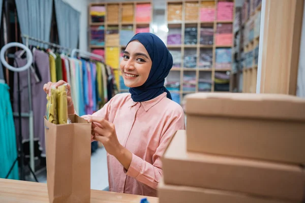 有吸引力的穆斯林妇女业主在装运前检查产品 — 图库照片