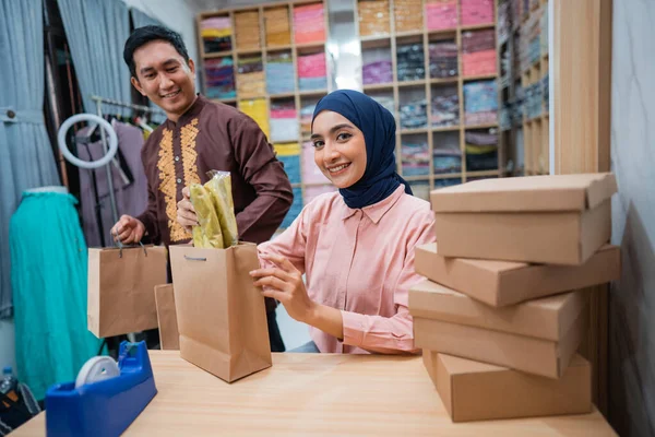 穆斯林妇女和男子在商店准备送货包裹 时装店的电子商务投递服务 — 图库照片