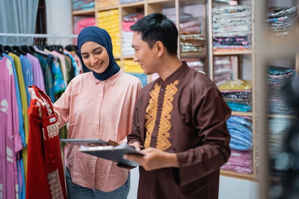 亚裔穆斯林妇女和男子在商店里检查他们的时尚产品 — 图库照片
