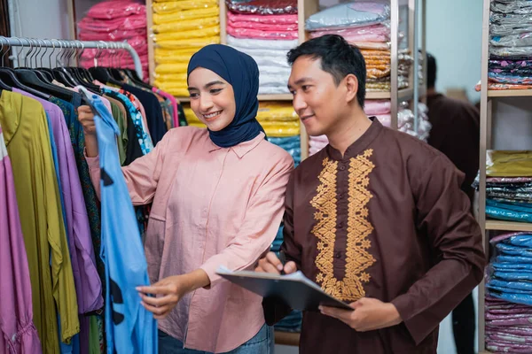 亚裔穆斯林妇女和男子在商店里检查他们的时尚产品 — 图库照片