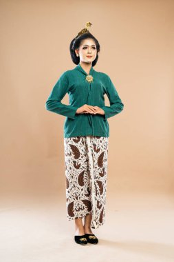 Geleneksel Java kabilesi kıyafetleri içinde Asyalı bir kadın elini vücudunun önüne koydu.