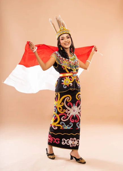 アジア系の女性は大きな立ち位置に立ち身体の後ろにインドネシアの旗を振り — ストック写真