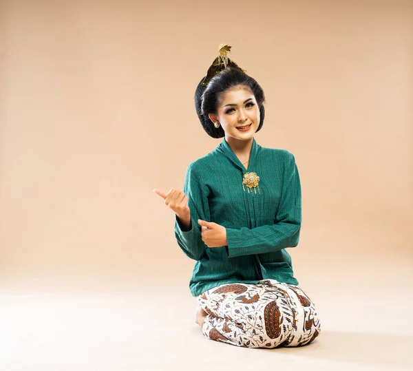 Yeşil Kebaya Giymiş Güzel Bir Javalı Kadın Yerde Oturuyor Parmaklarıyla — Stok fotoğraf