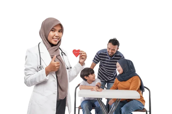 健康診断のために訪れた家族を笑顔にするイスラム教徒の医者の肖像 — ストック写真