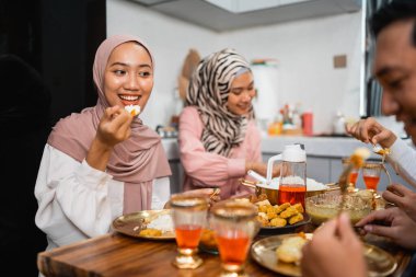 İki müslüman kız arkadaş evde iftar yemeği yerken sohbet ediyorlar.