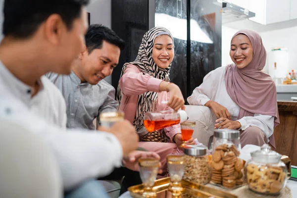 Muslim families get together while celebrating Idul Fitri cheering a glass at home