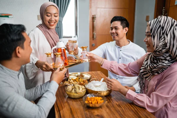 Мусульманська Жінка Подає Напій Свого Друга Сім Вдома Обідаючи Разом — стокове фото