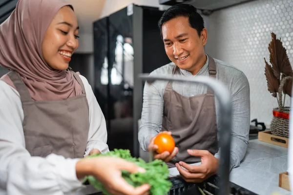 幸せな若いイスラム教徒のカップルが家で一緒に食べ物を作る — ストック写真