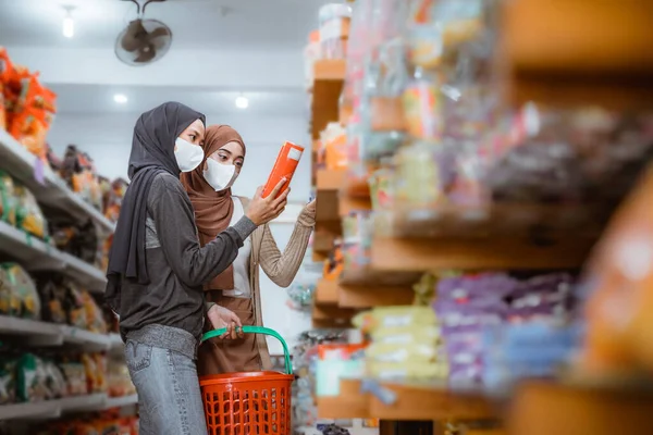 Twee Moslim Meisjes Maskers Observeren Items Tijdens Het Winkelen Samen — Stockfoto