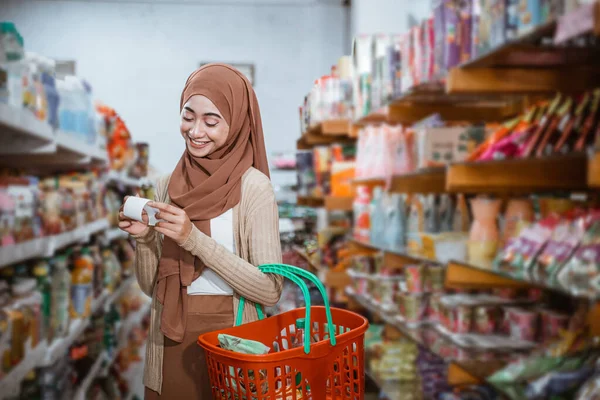Mulher Muçulmana Checando Recibo Compras Enquanto Carrega Cesta Supermercado — Fotografia de Stock