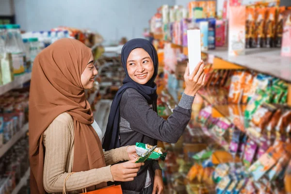 Duas Meninas Muçulmanas Sorrindo Enquanto Seguravam Embalagem Produto Supermercado — Fotografia de Stock