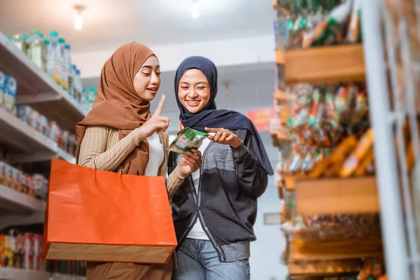Zwei Muslimische Mädchen Masken Beobachten Gegenstände Beim Gemeinsamen Einkaufen Einem — Stockfoto