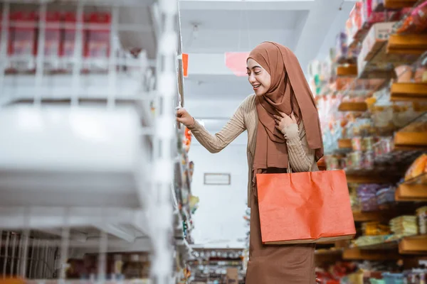 スーパーで買い物するときに赤い袋を持っているイスラム教徒の女性 — ストック写真