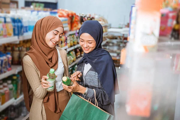Dvě Muslimské Dívky Maskách Pozorování Položky Při Nakupování Společně Obchodě — Stock fotografie