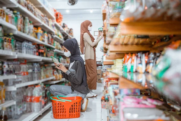 Twee Meisjes Maskers Zoek Naar Items Plank Tijdens Het Winkelen — Stockfoto