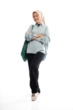 Kız peçeli üniversite öğrencisi sırt çantasıyla karşıdan karşıya geçiyor.