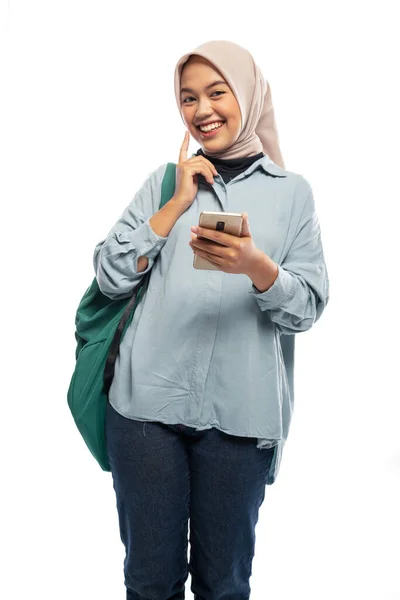 かわいいイスラム教徒女子大生は孤立した背景でバックパック付き携帯電話を持ち — ストック写真