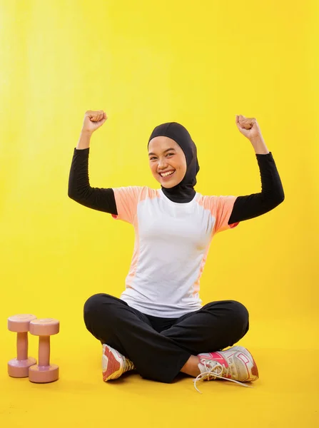 笑顔アジアのイスラム教徒女性でスポーツウェアで手を上げました上の黄色の背景 — ストック写真